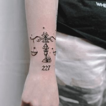 Minimalist Libra zodiac symbol tattoo on the achilles.